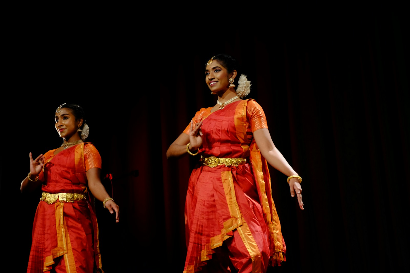 Two women perform traditional indian dance.